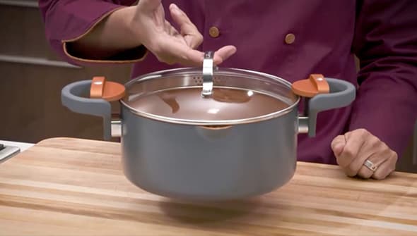 Holding the pot by its lid handle demonstrating the twist and lock handles